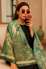 A woman wearing a green and gold-colored silk dupatta with a bird print, holding a pink rose to her face.