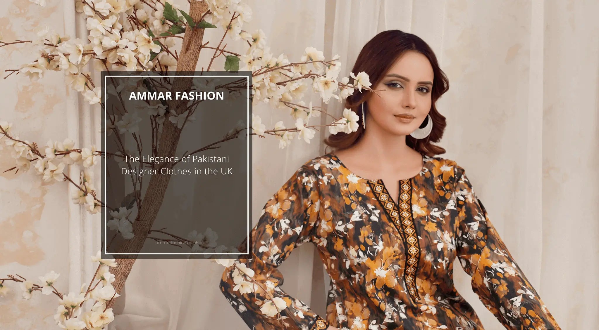 a girl in black and yellow beautifully mesh printed pakistani suit, sitting with a wall alongside a pant of white lilies with flowers on it.